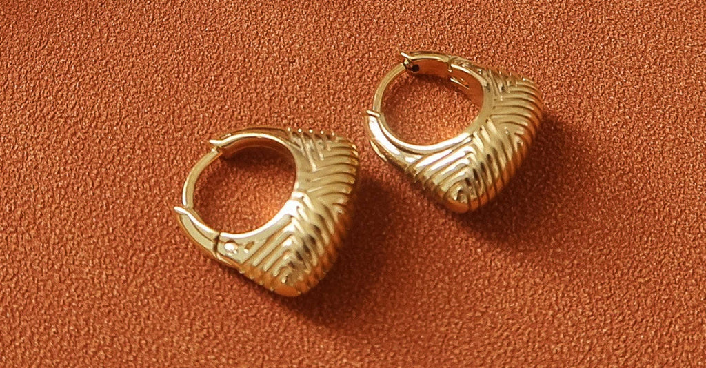 18k gold-plated textured hoop earrings on orange surface