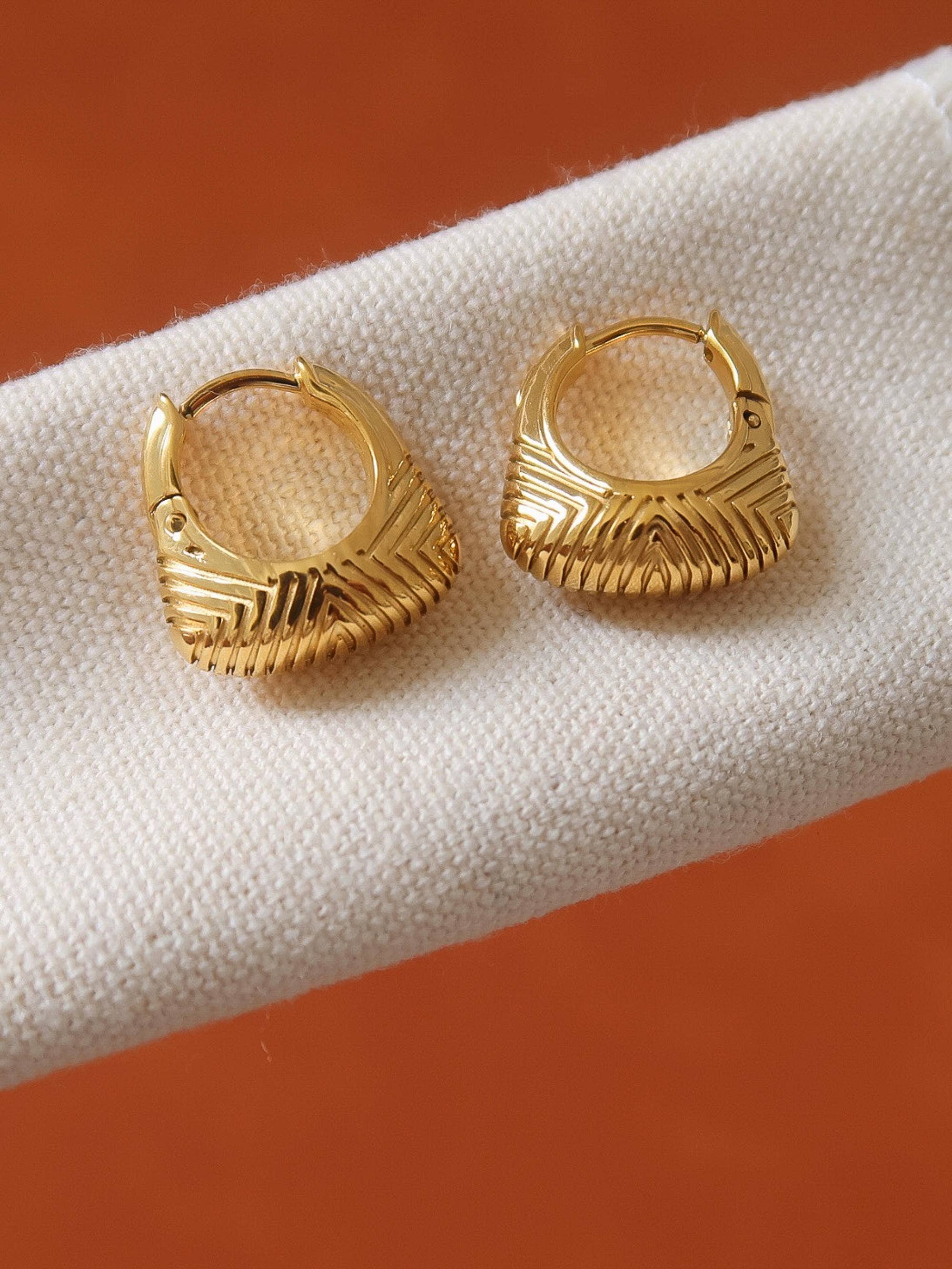 18k gold-plated textured hoop earrings on white surface