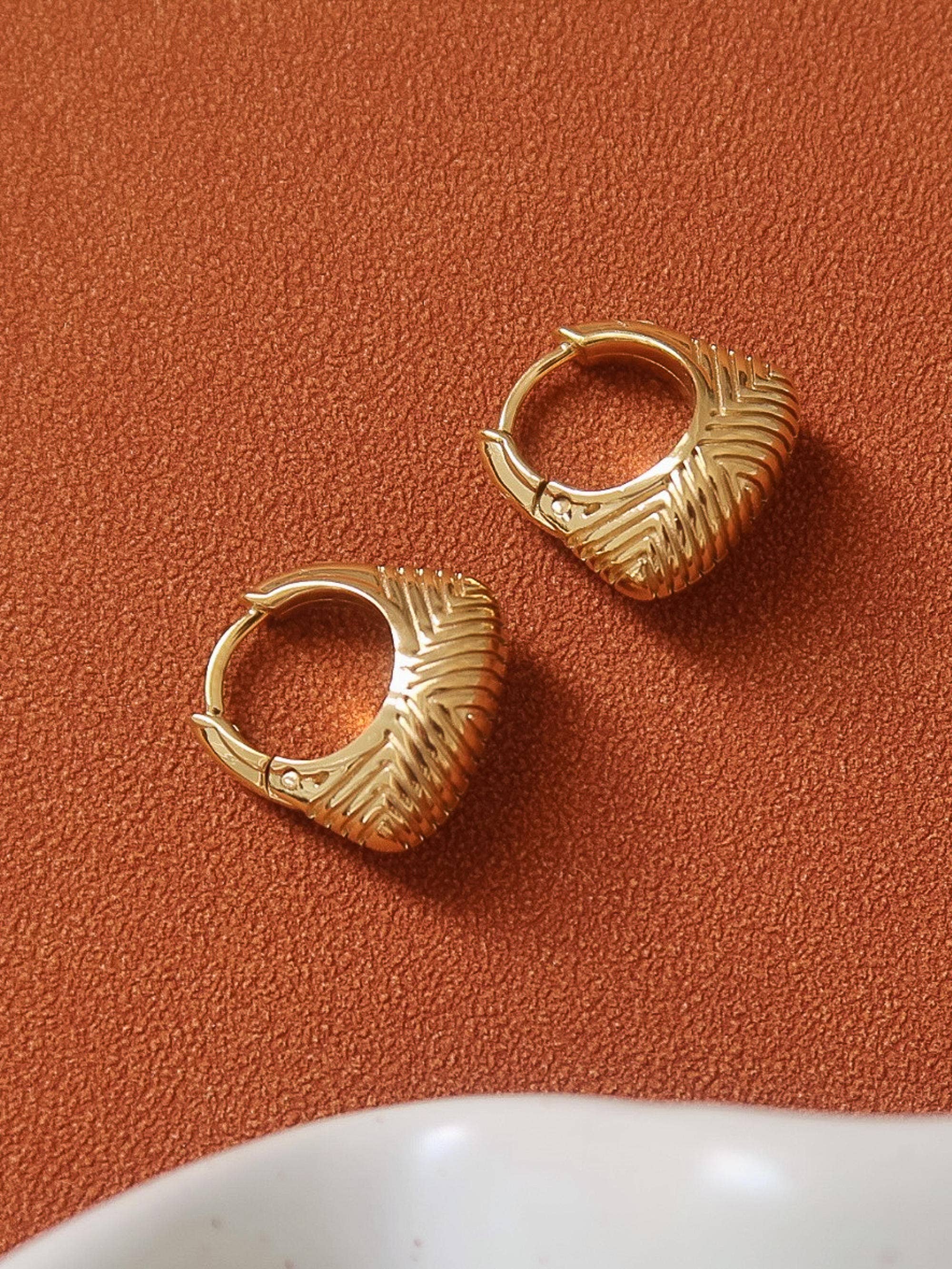 18k gold-plated textured hoop earrings on orange surface