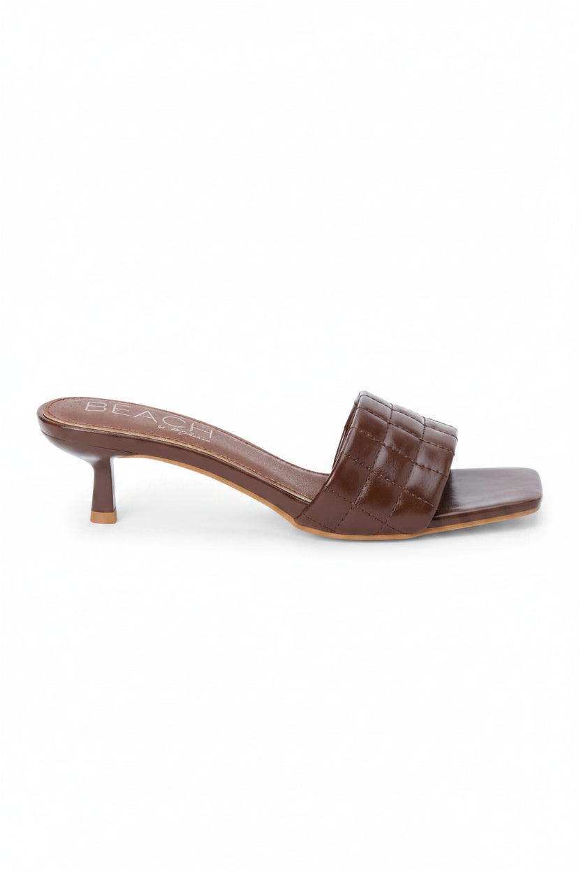 Brown croc detail slip on slide with a kitten heel on a white background