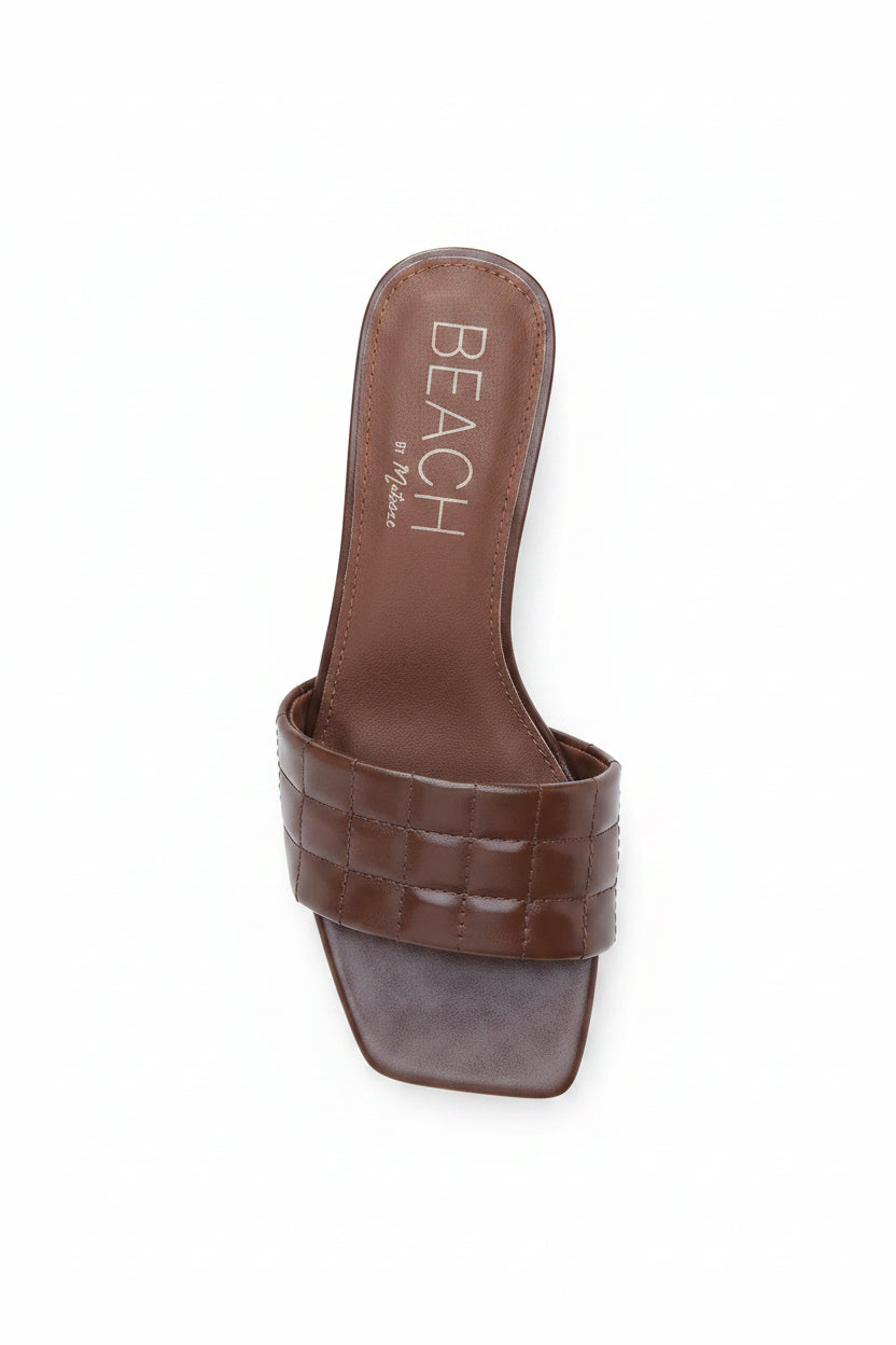 Brown sandal with 'BEACH' branding on a white background