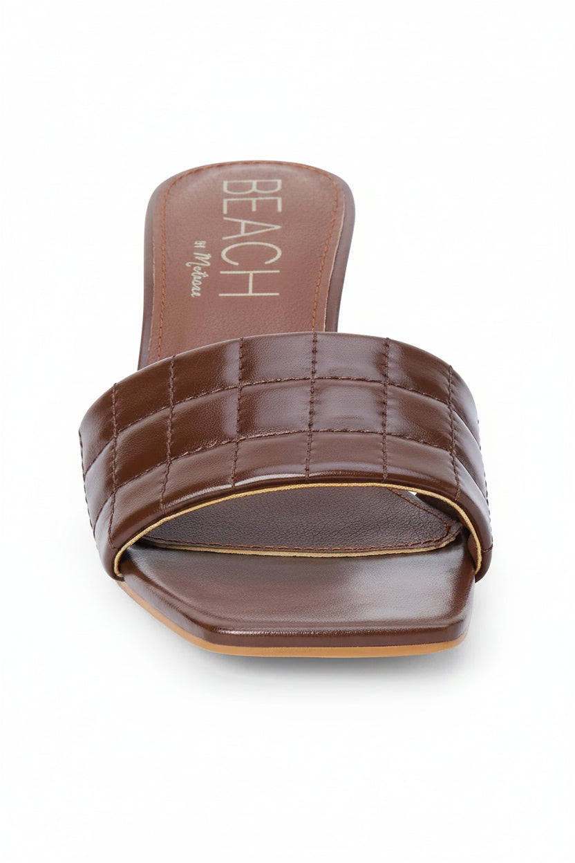 Brown quilted sandal on a white background