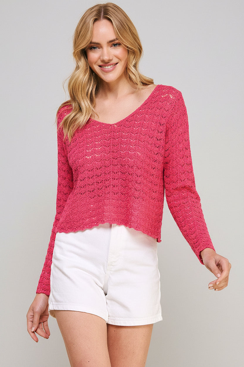 Woman wearing a hot pink crochet top and white shorts on a beige background