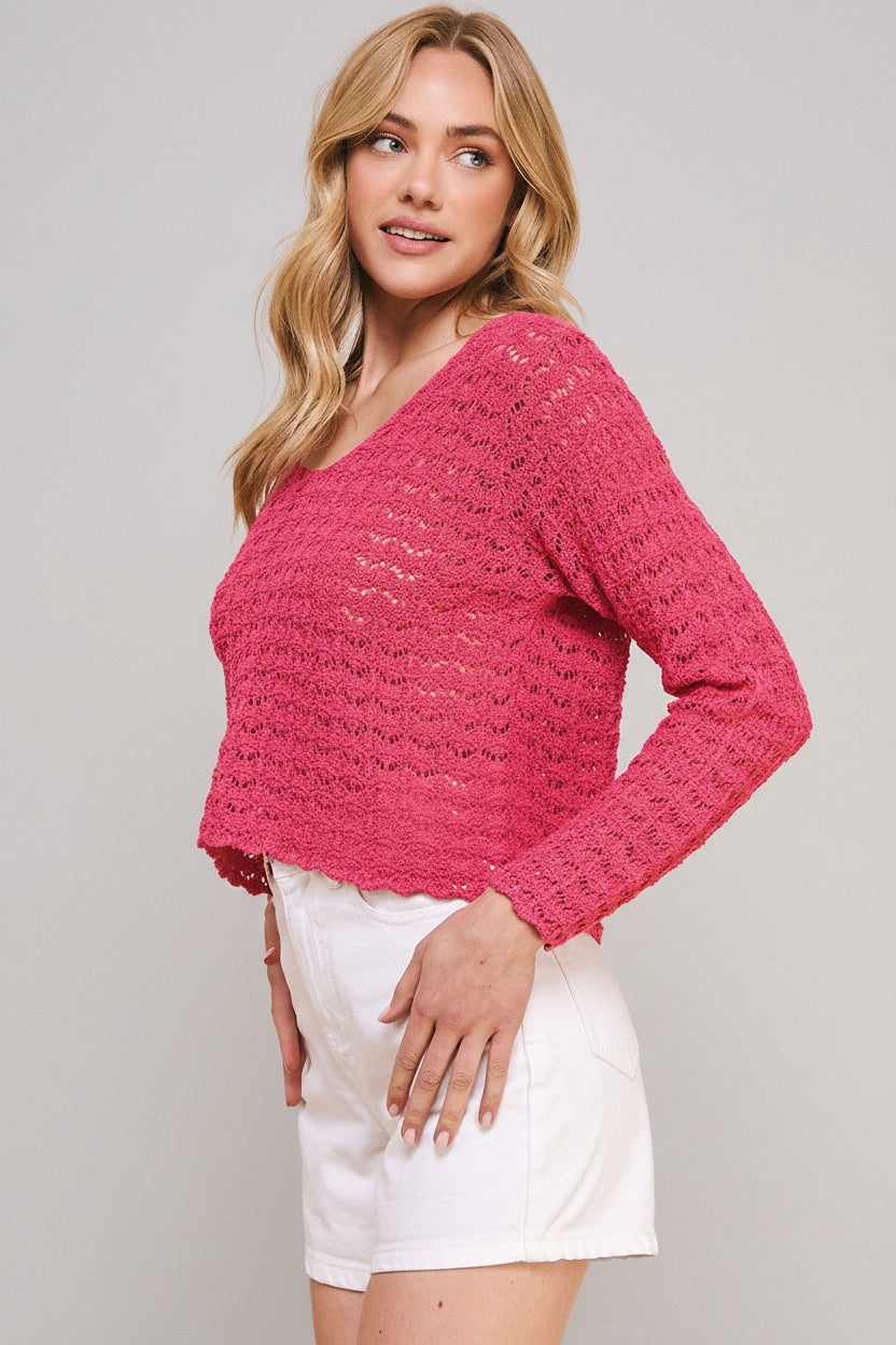 Woman wearing a hot pink crochet top and white shorts on a beige background