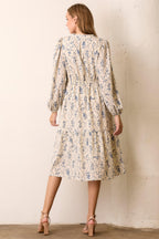 Back view of woman wearing floral maxi dress against a white background