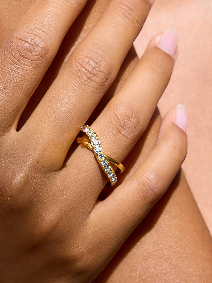Woman wearing a crossover gold and CZ ring 