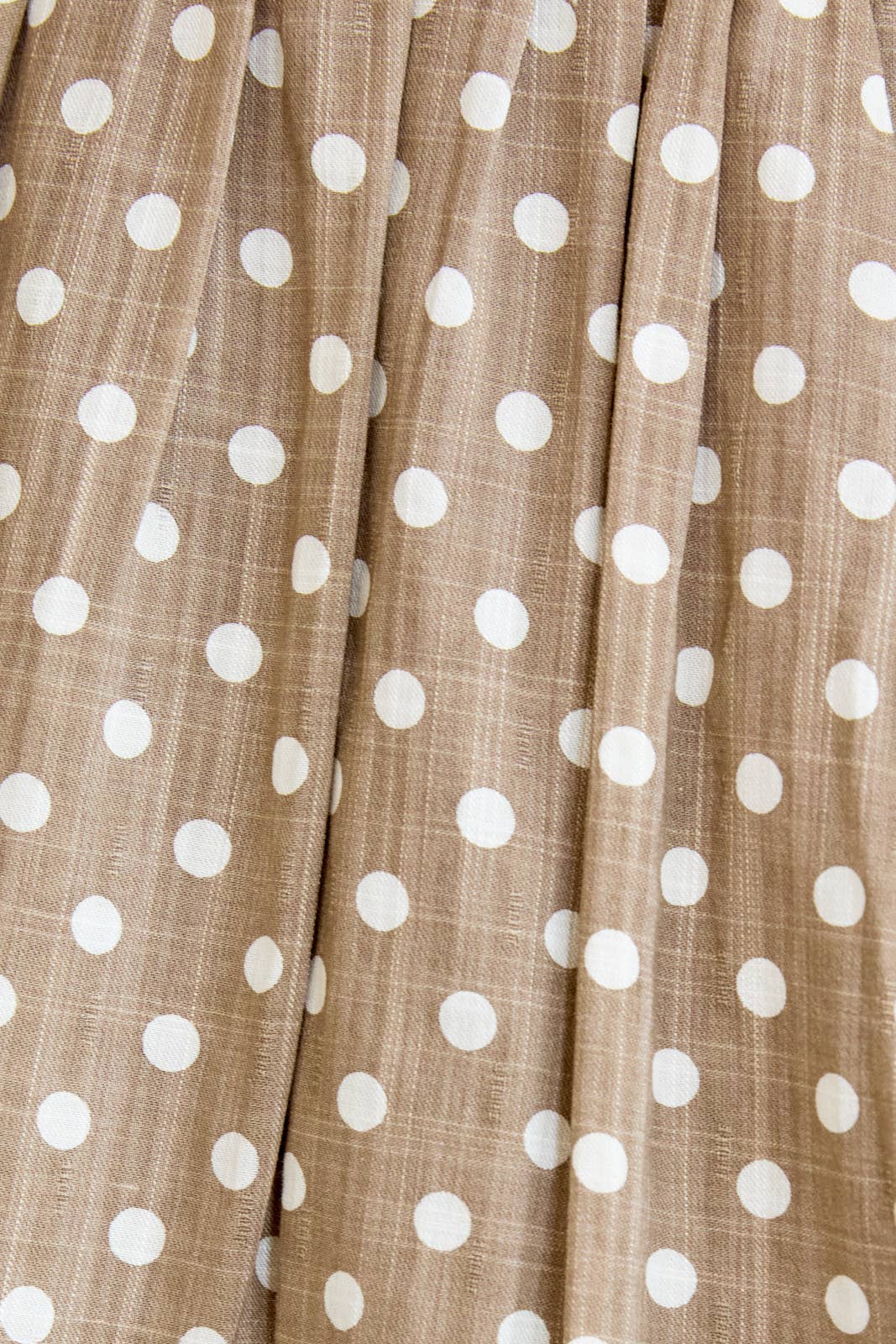 Close-up of tan fabric with cream polka dots