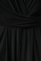 Close-up of the front wrap bodice, rushed sash and front pant pleats, showing the texture and folds of a wrap-style dress or top.