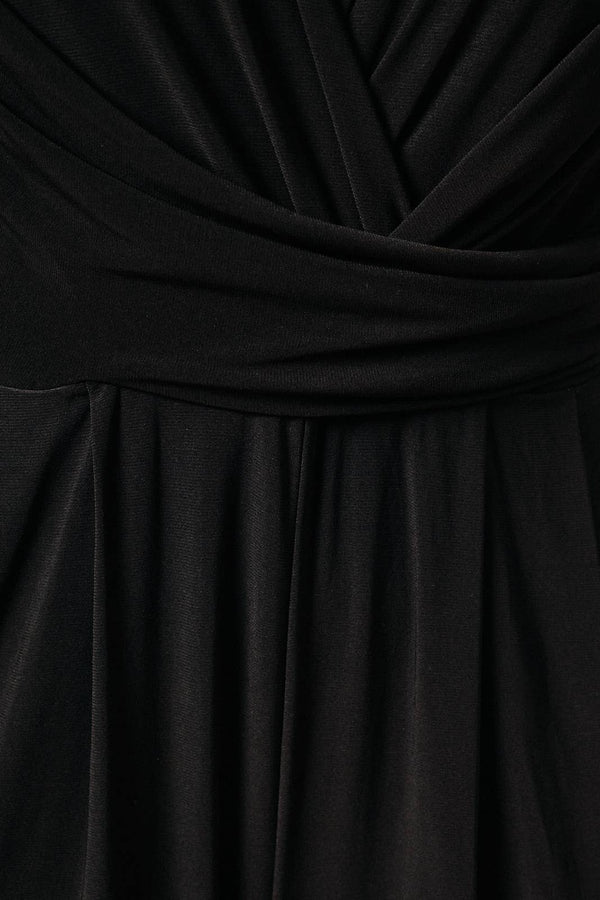 Close-up of the front wrap bodice, rushed sash and front pant pleats, showing the texture and folds of a wrap-style dress or top.