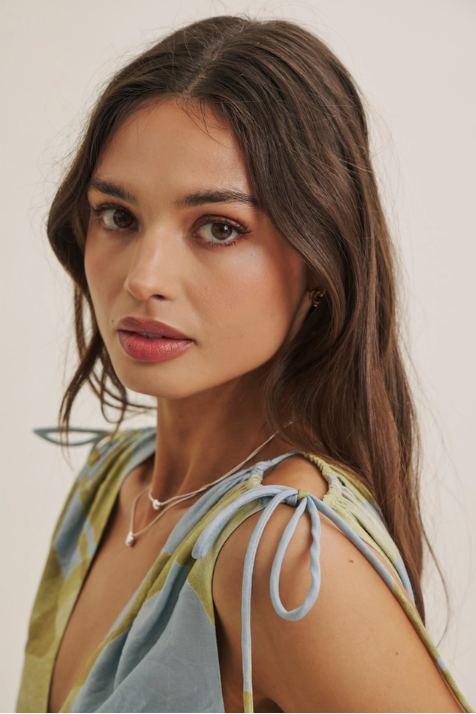Woman wearing a colorful top with a neutral background