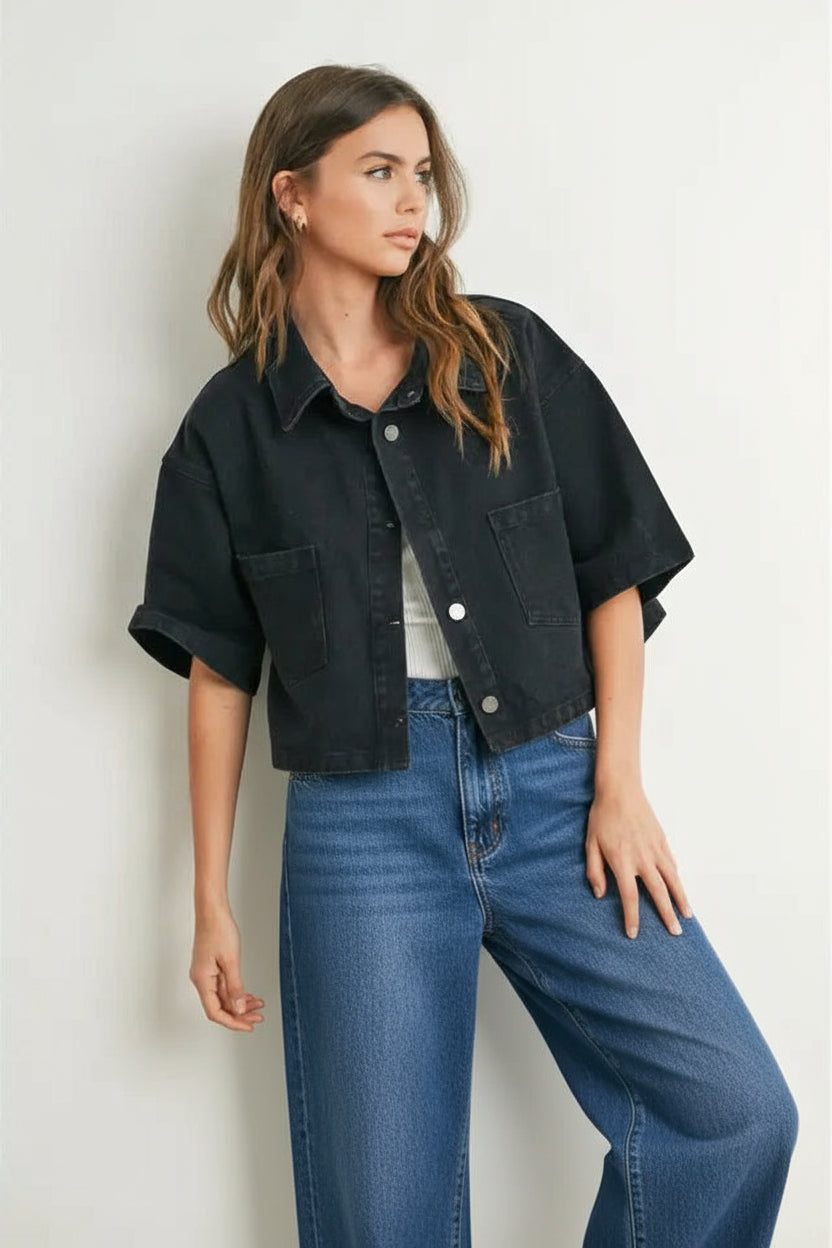 Woman wearing a black denim cropped top and checkered shorts against a white background