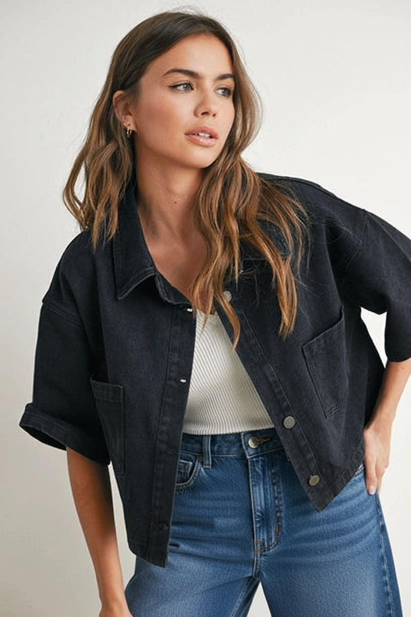Woman wearing a black denim cropped top with white top, and checkered pants on a plain background