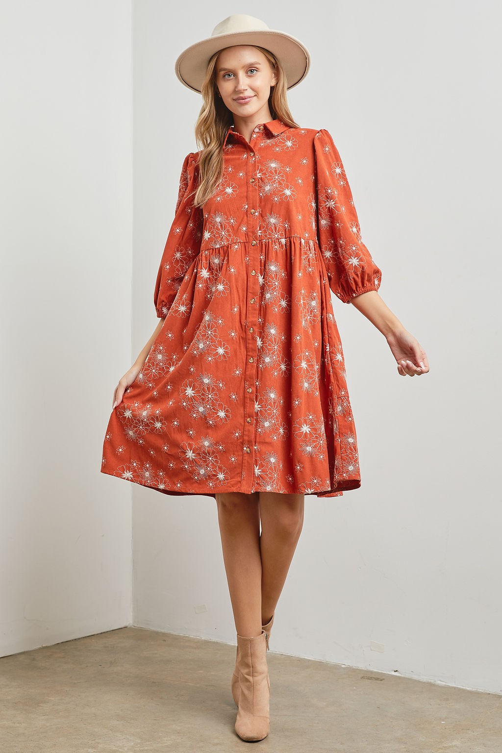 Woman wearing rust floral design tiered corduroy midi dress
