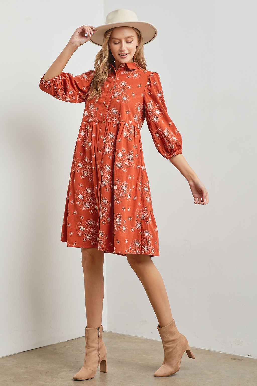 Woman wearing rust floral design tiered corduroy midi dress