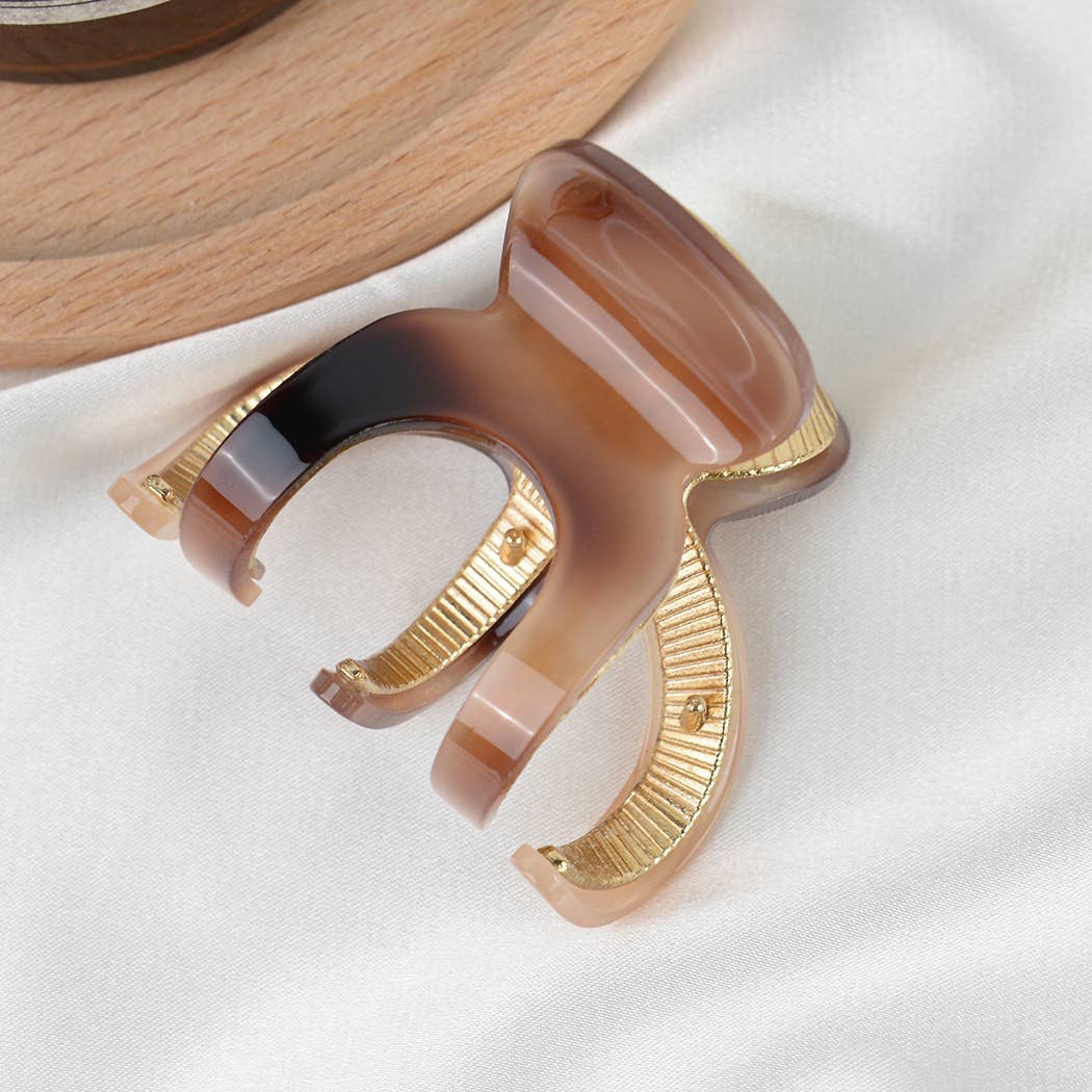 Decorative hair clip with gold and brown accents on a white background