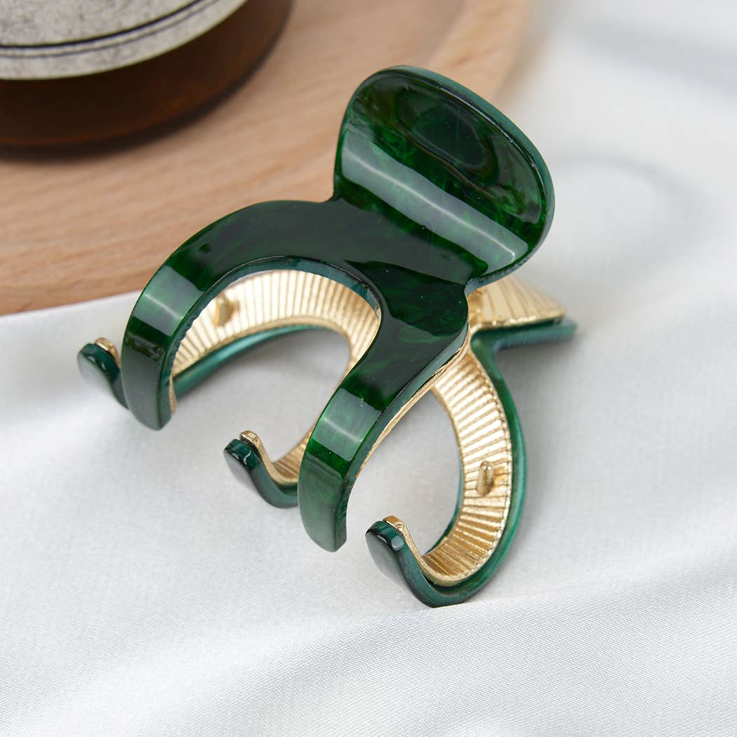 Green and gold tone pumpkin shaped hair claw on white background