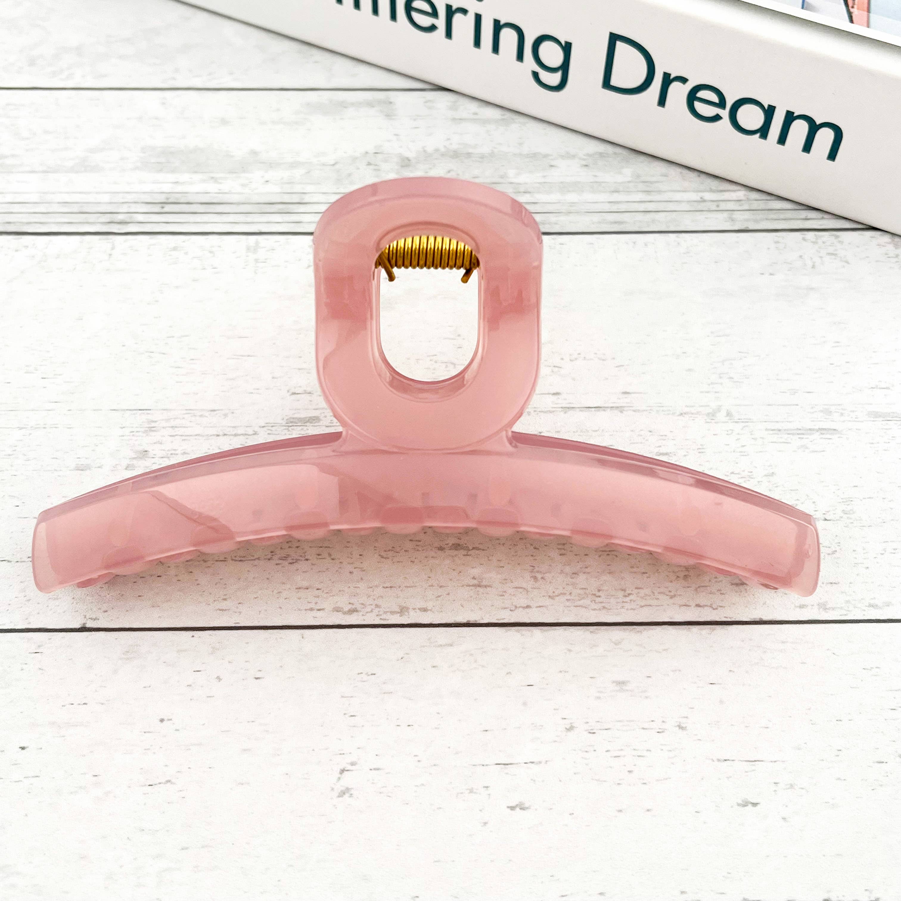 Pink hair claw on a light wooden surface 