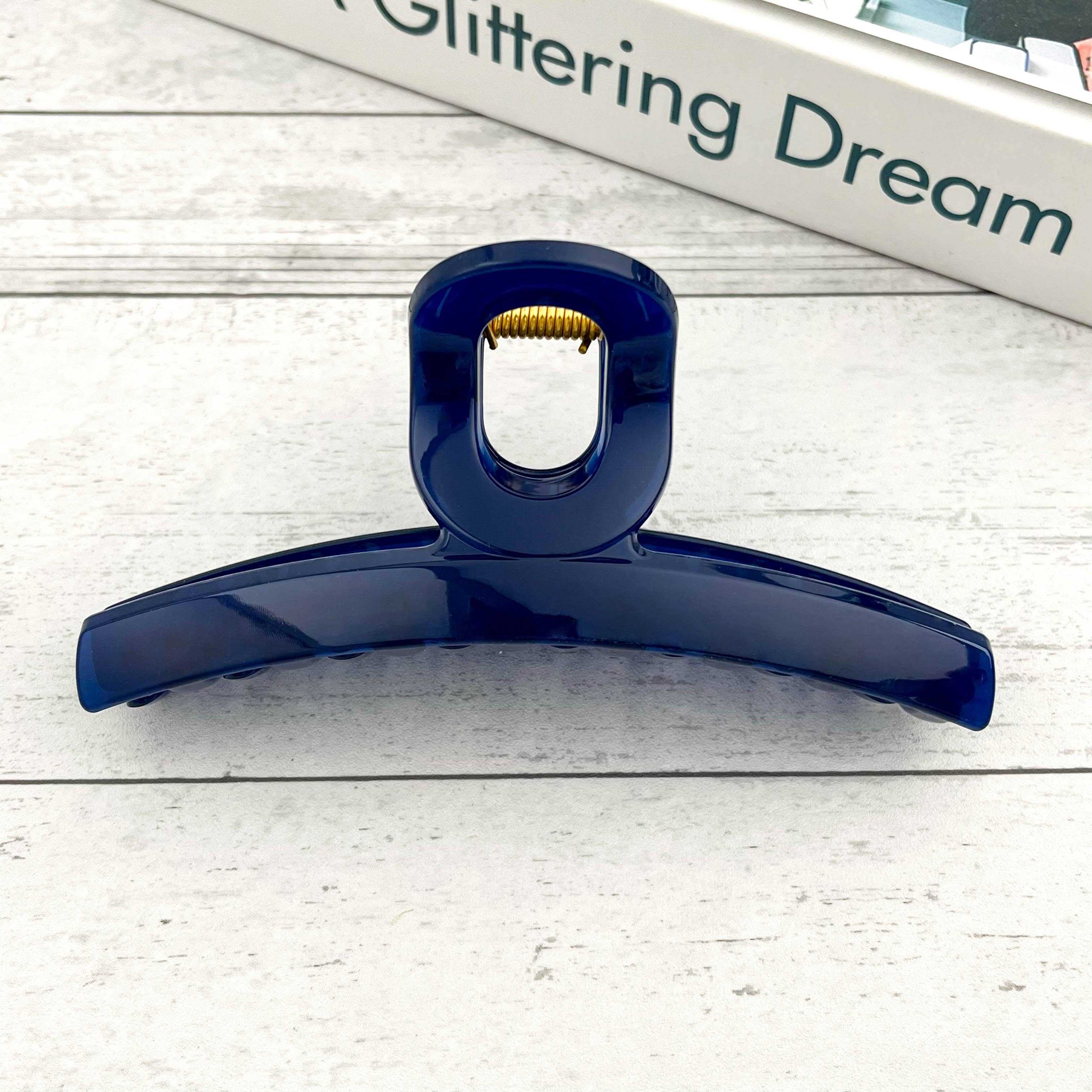 Blue hair clip on a light wooden surface 
