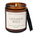 Candle in a brown jar with a label reading 'Sweet Water Decor Cinnamon Rols on a white background.
