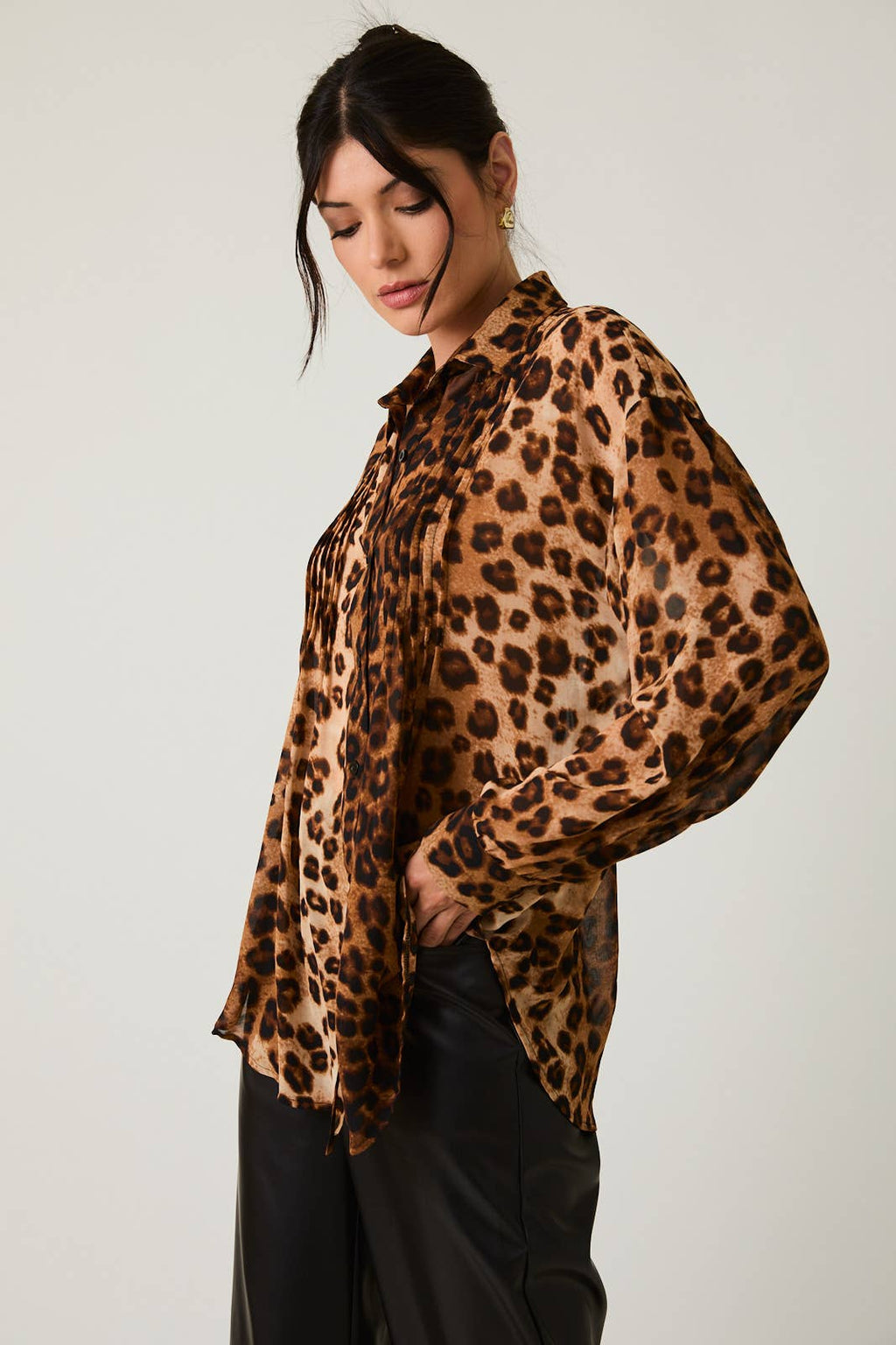 Woman wearing a leopard print blouse against a plain background