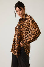 Woman wearing a leopard print blouse against a plain background