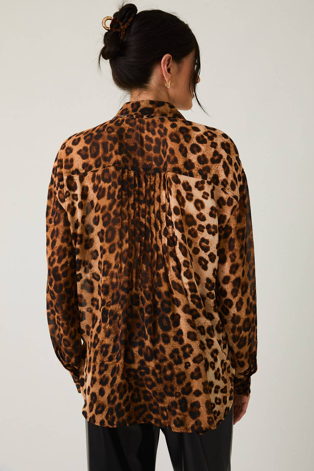 Woman wearing a leopard print blouse against a white background