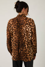 Woman wearing a leopard print blouse against a white background