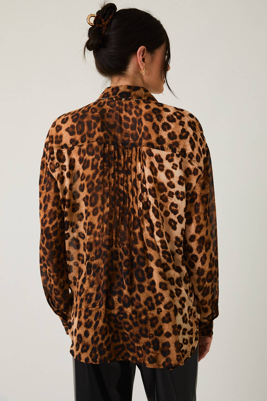 Woman wearing a leopard print blouse against a white background