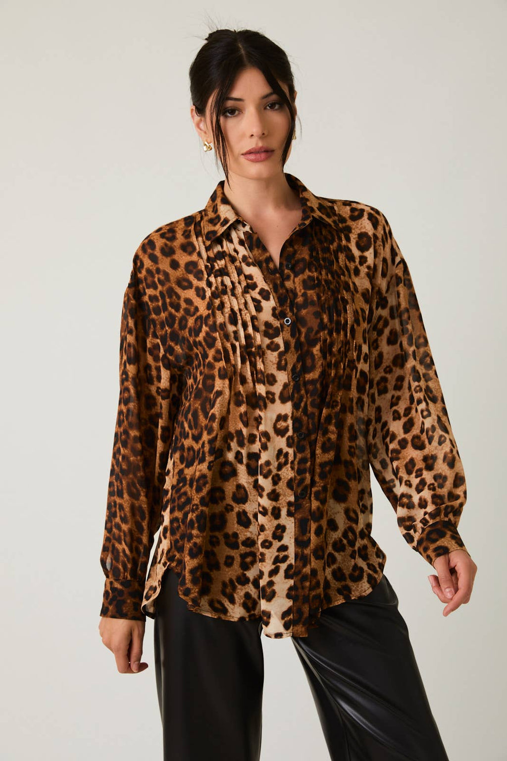 Woman wearing a leopard print shirt against a plain background