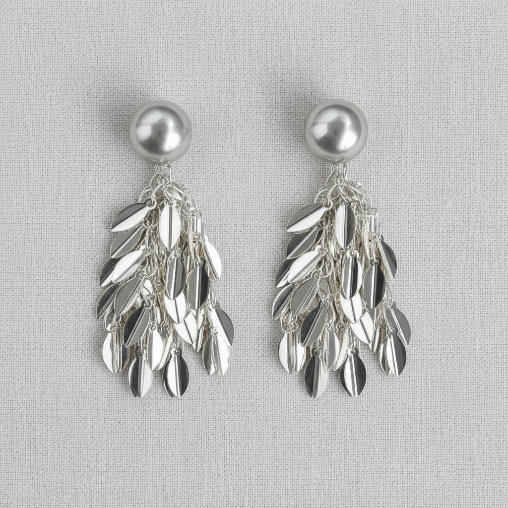 Pair of silver tone  leaf-shaped tassel earrings with ball stud on a light gray background