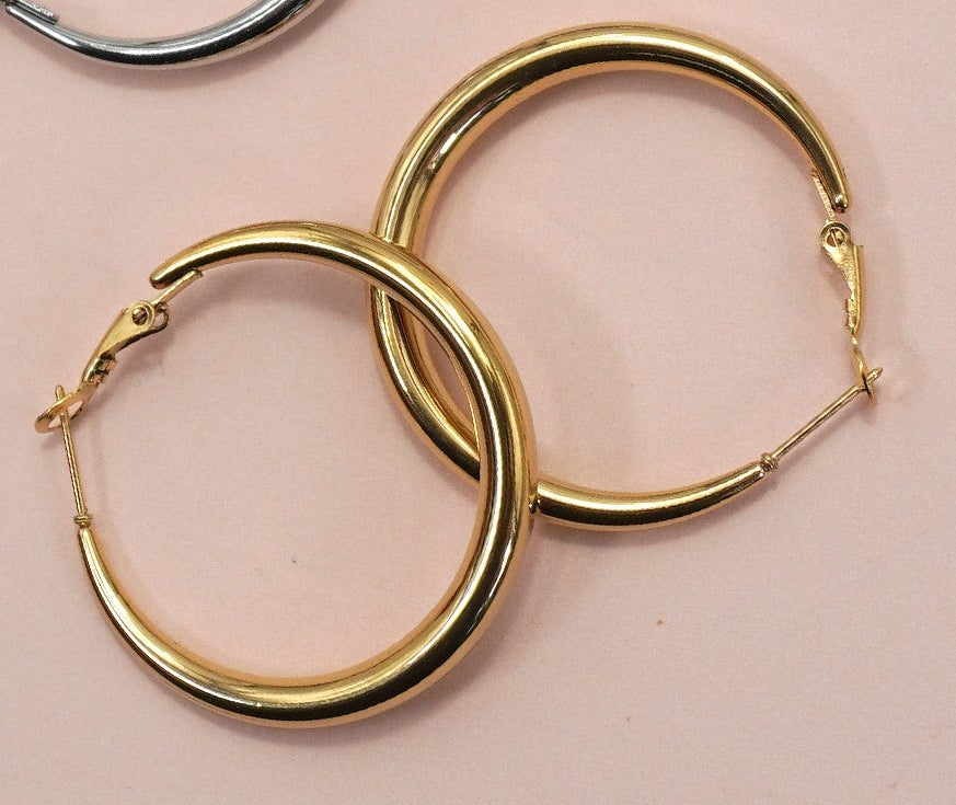 18k gold-plated puffy hoop earrings on a pink background