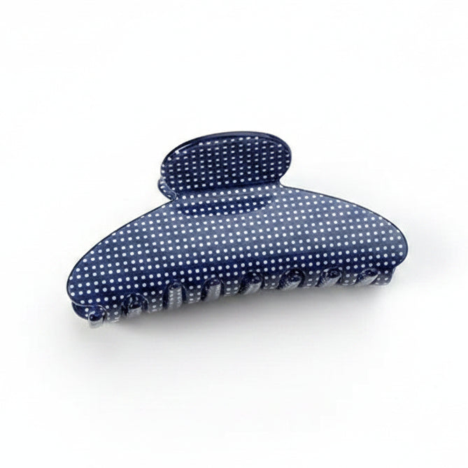 A dark blue hair claw clip with white polka dots, displayed on white background