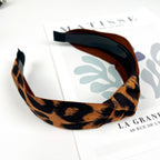 Women's brown leopard print top knot headband on a white surface
