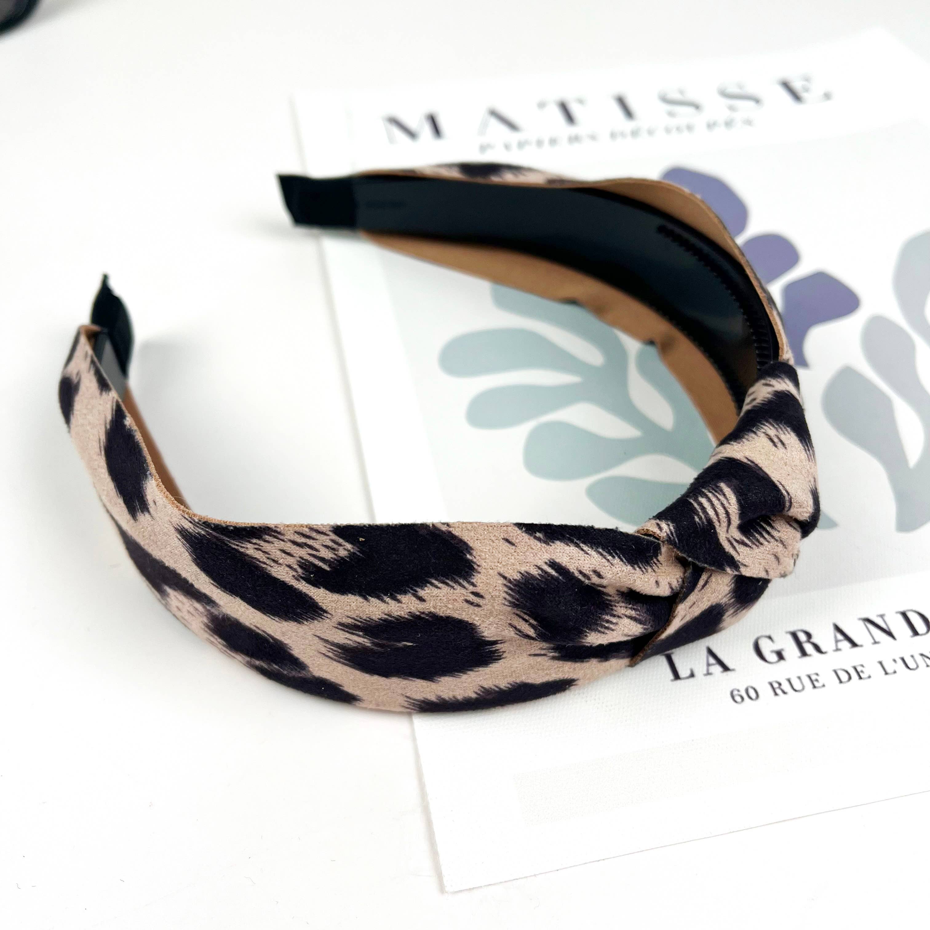 Women's taupe leopard print top knot headband on a white background