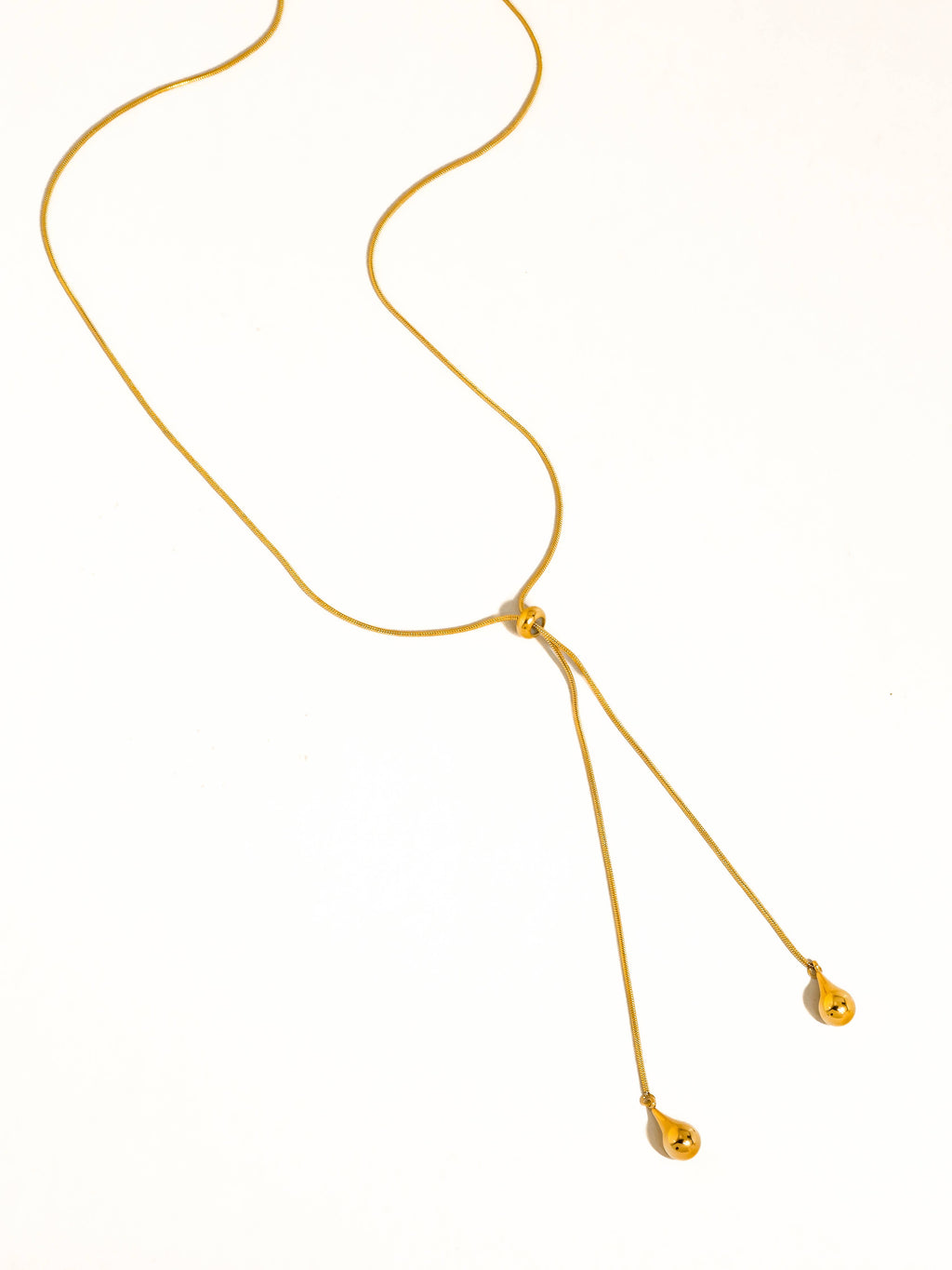 A delicate gold chain lariat drop necklace with teardrop pendants shown on a plain white background.