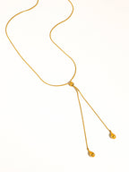 A delicate gold chain lariat drop necklace with teardrop pendants shown on a plain white background.