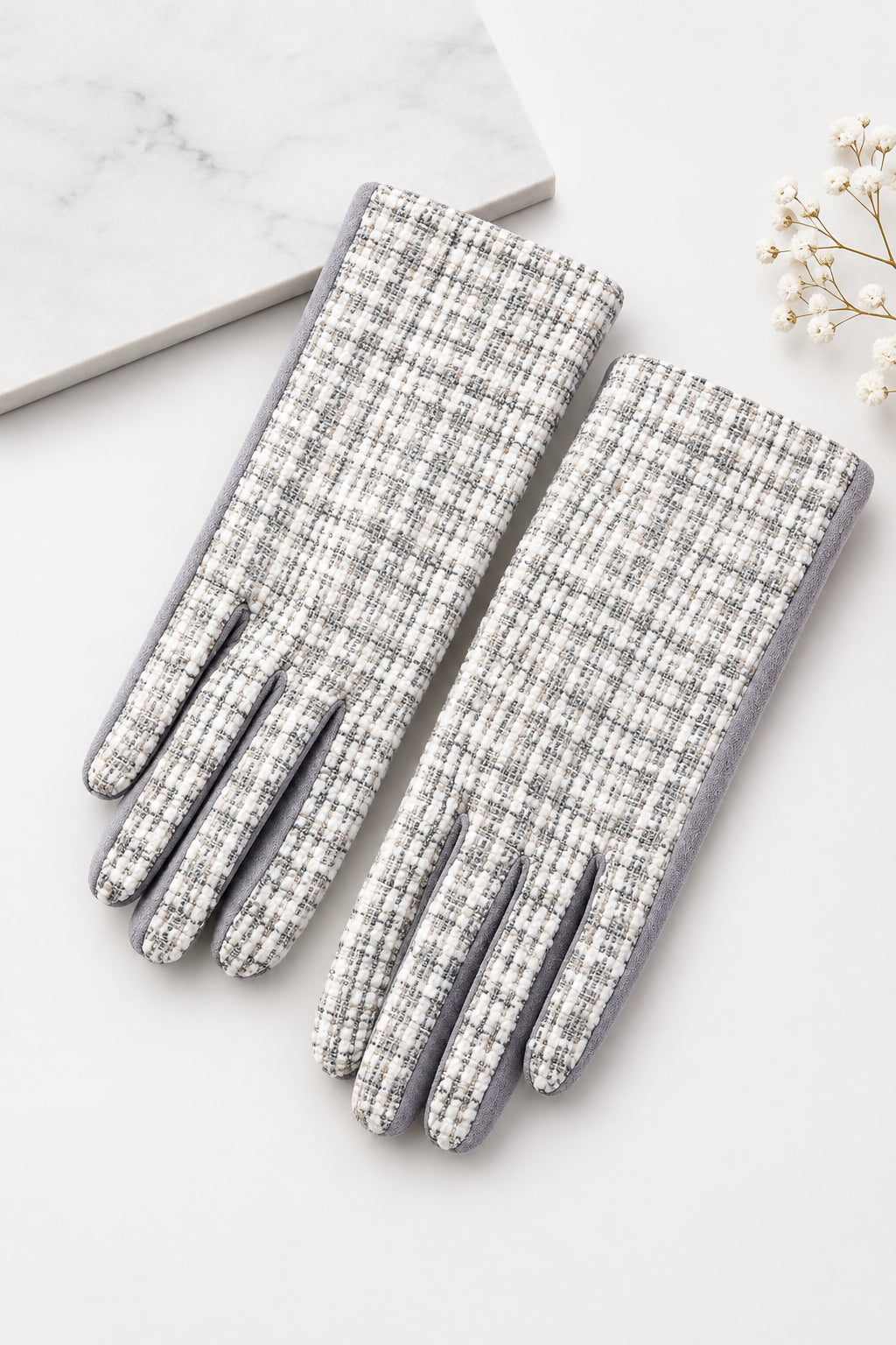Gray and white tweed woven hand gloves on a white background