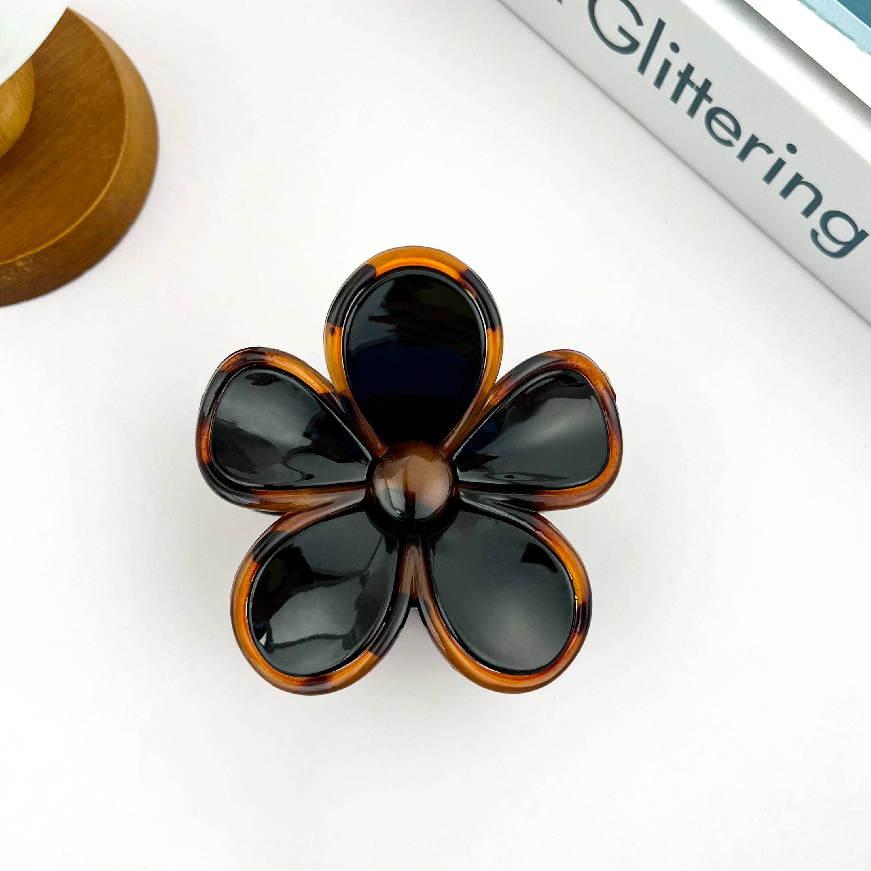 Flower-shaped hair claw with tortoise shell pattern on a white background