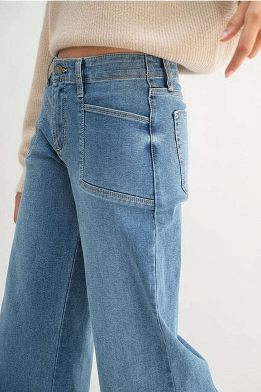 Medium wash wide leg jeans worn by a woman on a white background