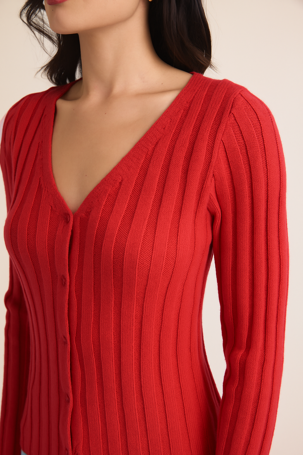 Woman wearing berry ribbed knit sweater on a beige background