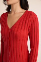 Woman wearing berry ribbed knit sweater on a beige background