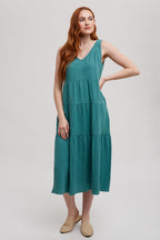 Woman wearing a sea green tank tiered dress on a white background