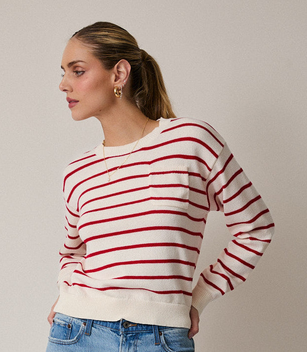 Woman wearing red and cream striped sweater on gray background