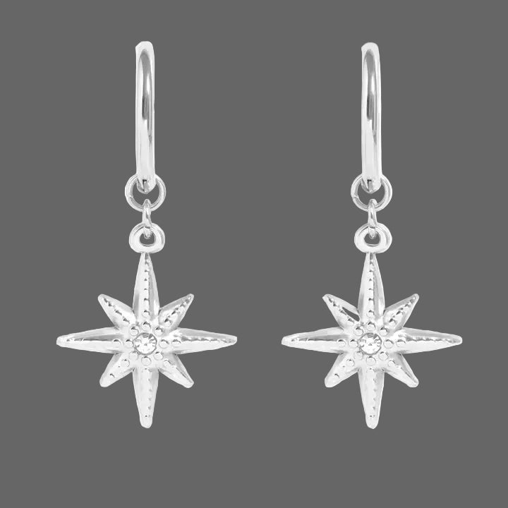 Stainless steel compass charm with cubic zirconia accent stone huggie earrings on a white background